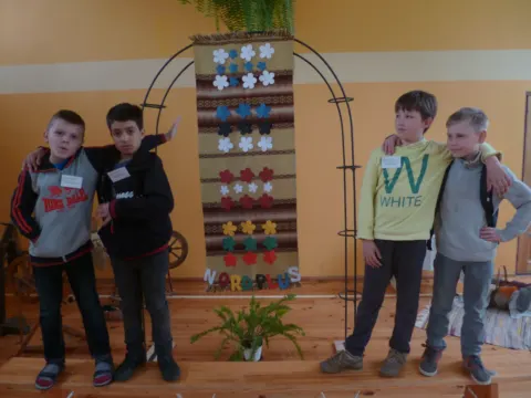 Mokiniai prie latvių tautinių audinių parodos