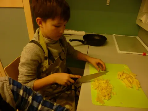 Mokinys pjausto bulves barščiams